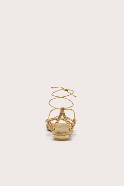 Back view of a metallic gold gladiator sandal with a slim heel.