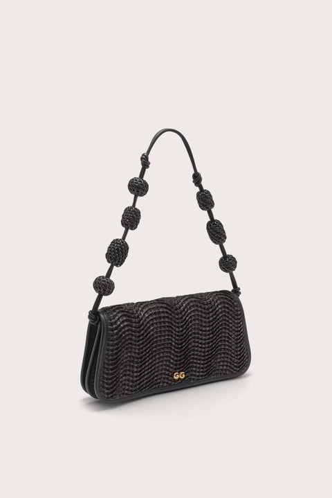 Side angle of a black wavy raffia shoulder bag with raffia beads on the shoulder strap. 