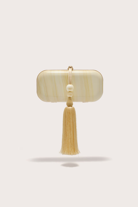 A soft, rectangular clutch crafter from marbled yellow acrylic, features a yellow beaded tassel adorning the hardware. 