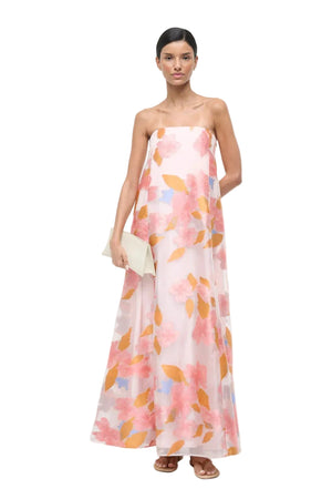 Woman wearing a floral strapless dress on a white background