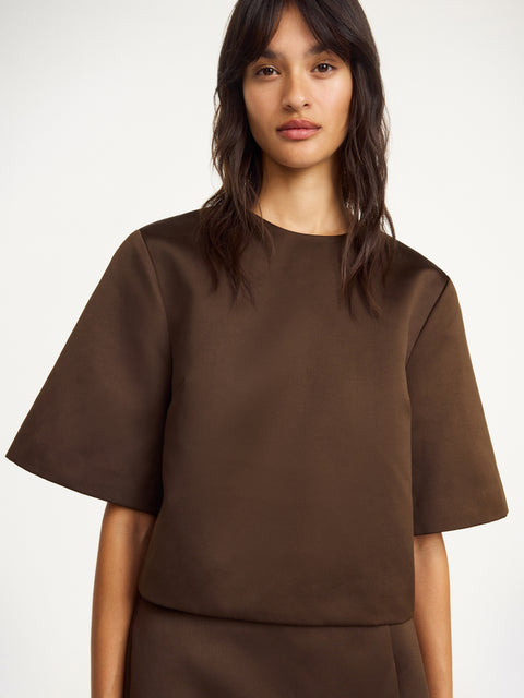 Up close of woman wearing brown satin top.