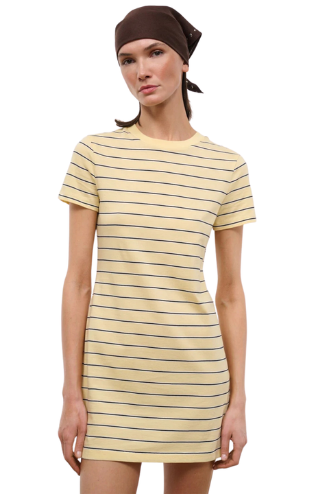 A woman modeling a short-sleeve crewneck t-shirt dress with thin horizontal navy blue stripes on a pale yellow base, paired with a dark brown headscarf, against a plain white background.