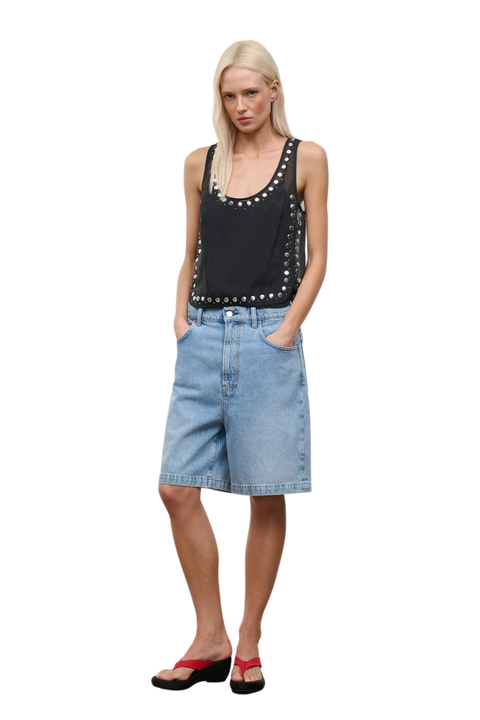 A woman wearing a black sheer organza sleeveless top with stud embellishments
