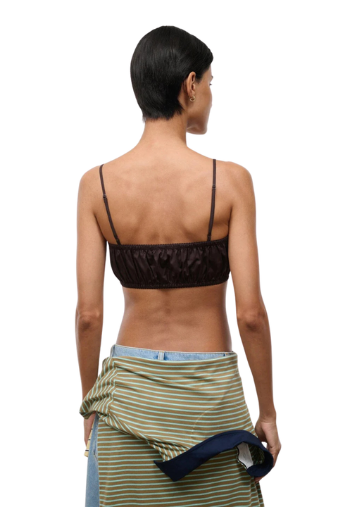 A model shown from the back wearing a dark brown ruffled spaghetti-strap bandeau top and a green and white striped sarong, against a plain white background.