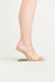 Side view of a raffia heel that features two over-the-foot straps and a gold-toned hollow, suspended heel. 