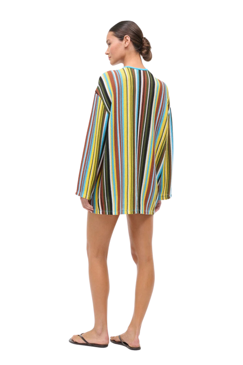 Woman wearing a colorful striped crochet dress on a white background back angle