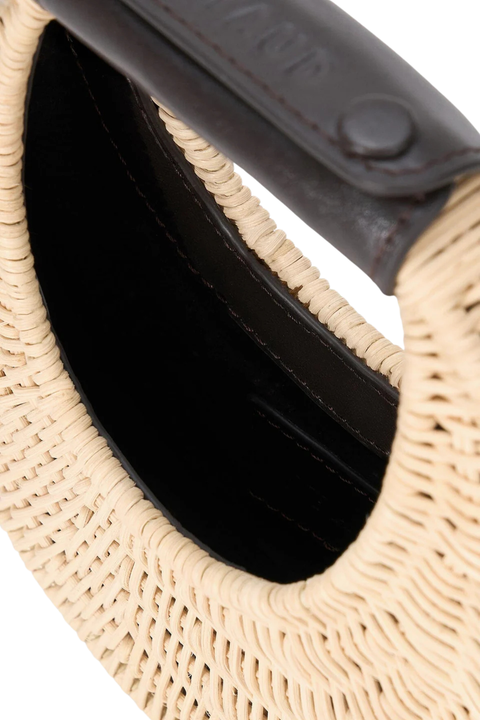 Close-up of a woven handbag with a brown handle on a white background
