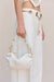 Detail shot of white, wide leg jeans that feature a gold chain belt detail with cutouts. 
