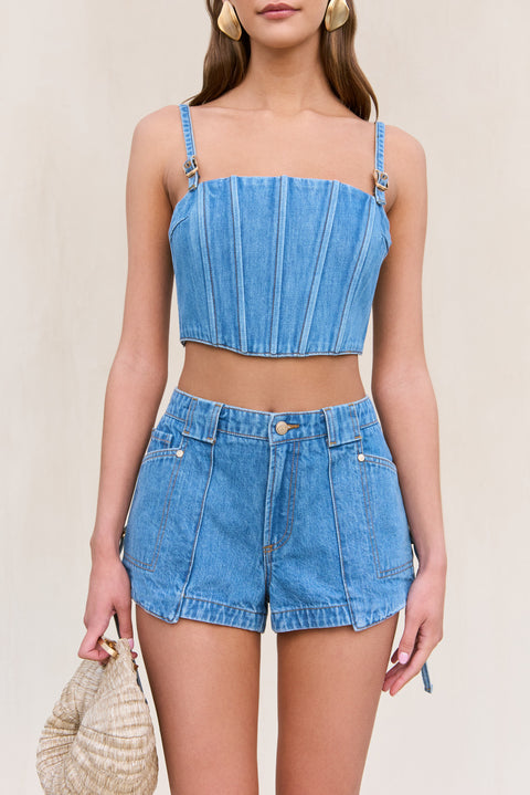 Up close look at a woman wearing a blue denim corset with matching cargo denim shorts. 