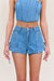 Up close view of a woman wearing blue denim cargo shorts with a matching blue denim corset. 