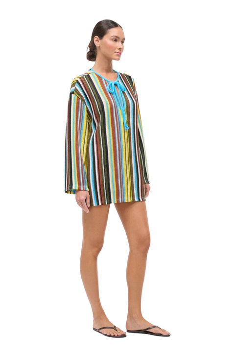 Woman wearing a colorful striped crochet dress on a white background
