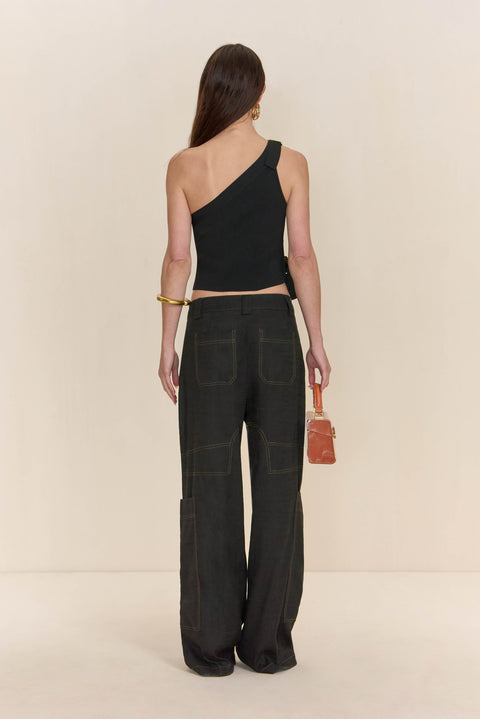 Back view of a woman wearing a black asymmetrical shirt paired with black cargo pants.