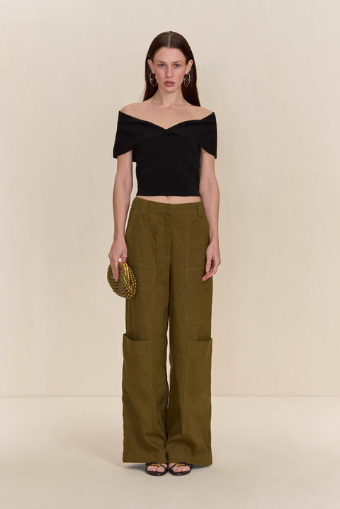 Woman wearing olive green cargo pants paired with a black off-the-shoulder top.
