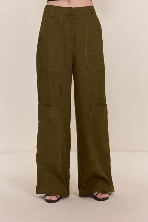 Close up shot of a woman wearing olive green cargo pants paired with black strappy sandals. 