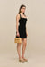 Side-facing woman wearing a black knit mini dress with a halter neck and square neckline. 