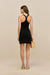 back-facing woman wearing a black knit mini dress with a racer back detail. 