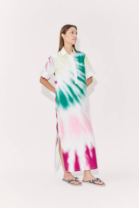 Woman looking sideways wearing tie-dye midi dress with collar and side slit.