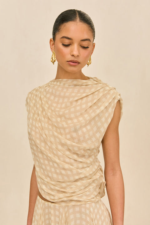 Detail shot of woman wearing a beige checkered outfit.