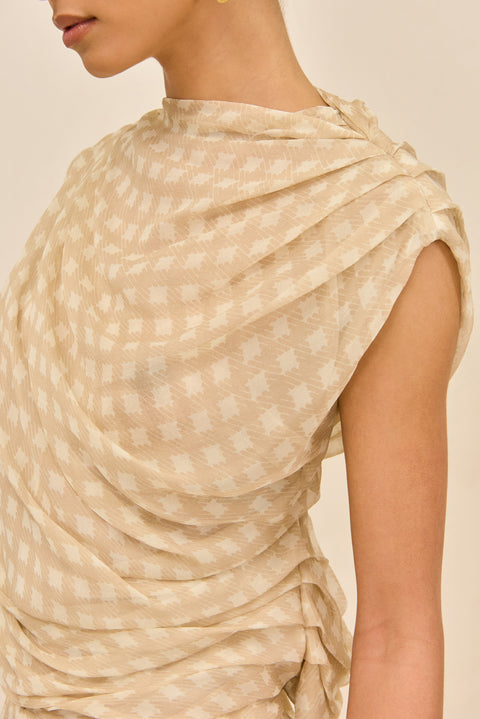Close-up detail shot of woman wearing a beige checkered outfit holding a yellow clutch against a white background
