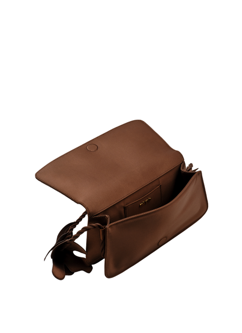 Brown handbag opened up with a floral strap on a white background