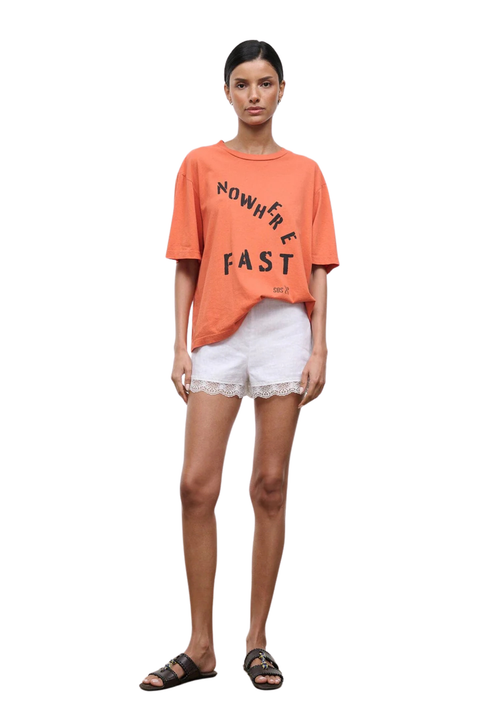 Woman wearing white linen mini shorts with a lace trim front angle