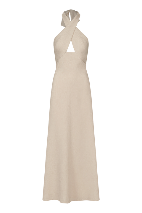 An ankle-length halter-neck dress in a light beige or cream color, featuring a crossover front neckline with a keyhole cutout