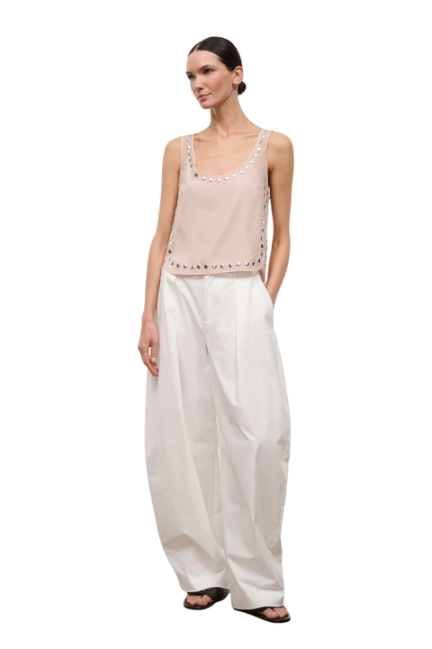 A woman wearing a pink sheer organza sleeveless top with stud embellishments