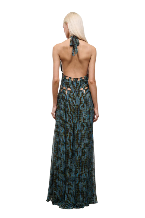 Woman wearing a blue and brown patterned halter neck maxi dress with cutouts and an open back