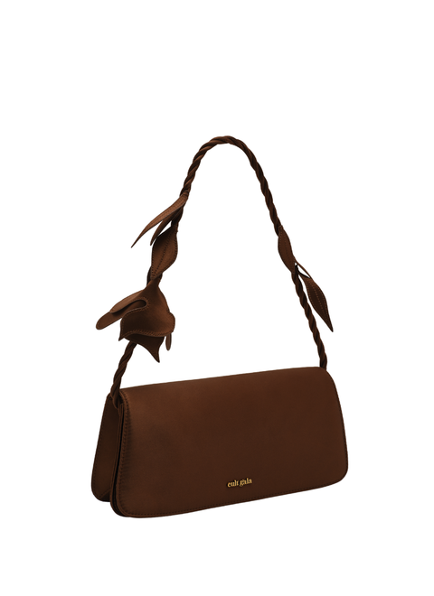 Brown handbag with floral strap facing upward on a white background