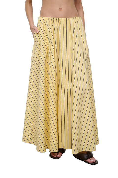 Woman wearing a yellow striped maxi skirt on a white background close up