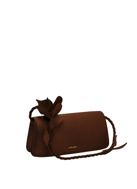 Brown handbag with a floral strap facing downward on a white background