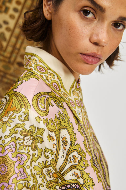 Detail shot of a woman wearing a multicolor, long sleeve shirt dress that features a point collar. 