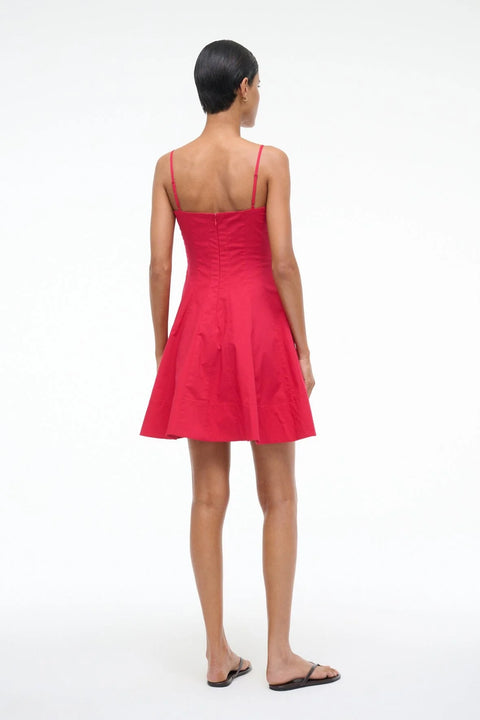 Woman wearing a red mini dress that features spaghetti straps, corset style paneling, and an A-line skirt, paired with black sandals. 