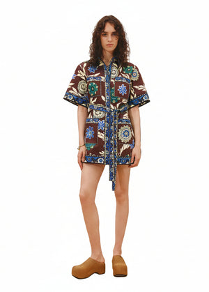 Woman wearing a mini patterned shirt dress on a white background