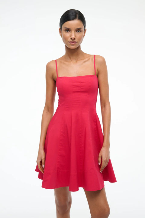 Close up of a woman wearing a red mini dress that features spaghetti straps and a straight neckline, corset style paneling, and an A-line skirt. 