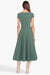 Model facing the back in the green short sleeve midi dress