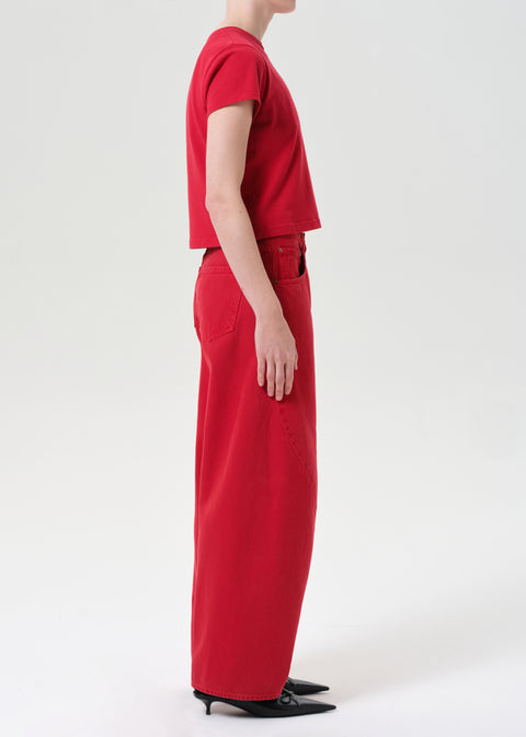 Side view of person wearing red jeans and red t-shirt on a white background
