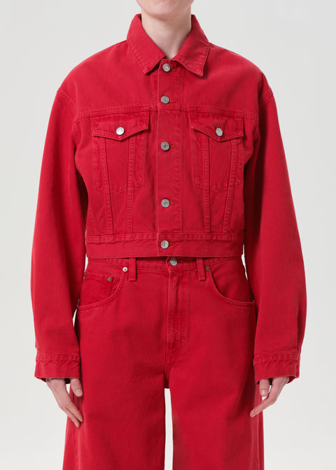 Up close of person wearing a red denim jacket and red denim pants on a white background