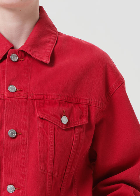 Close-up of a red denim jacket with button details on a plain background