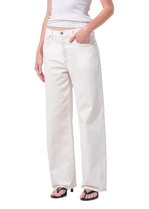 Person wearing white wide-leg, mid-rise jeans and a white top on a white background from the front