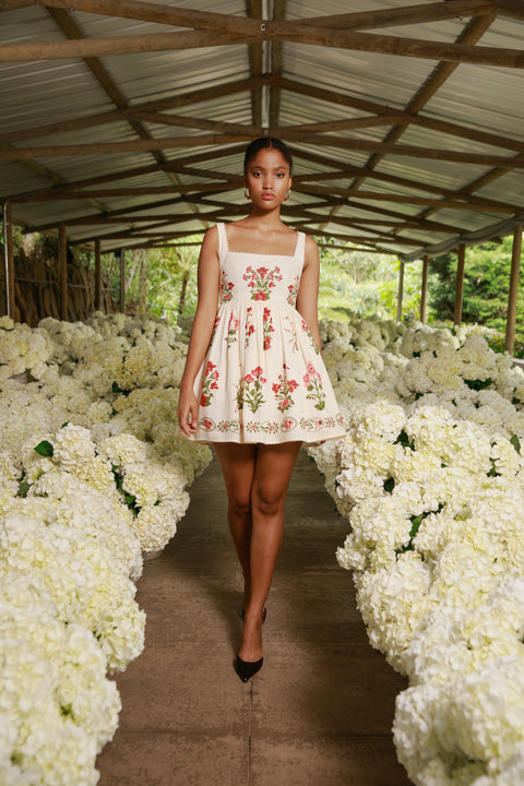 Model walks runway lined with white florals in a-line mini dress in floral print.