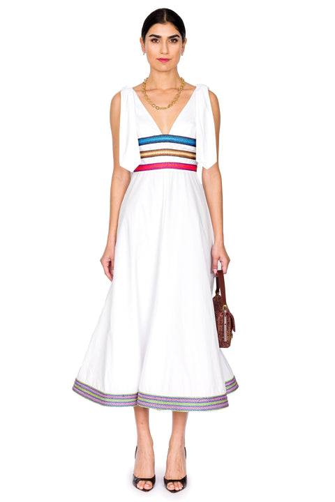 Model wears white v-neck midi dress with ribbons of raffia.