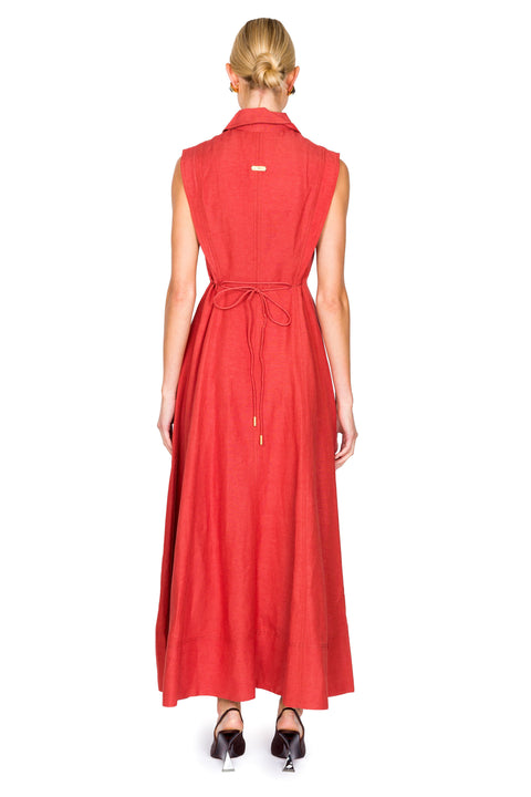 Woman facing away wearing a red maxi sleeveless dress with tie on a white background from the back