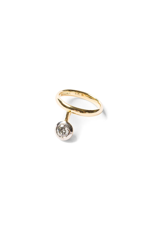 Gold ring with a round diamond set in a white gold bezel suspended on a gold stick. 