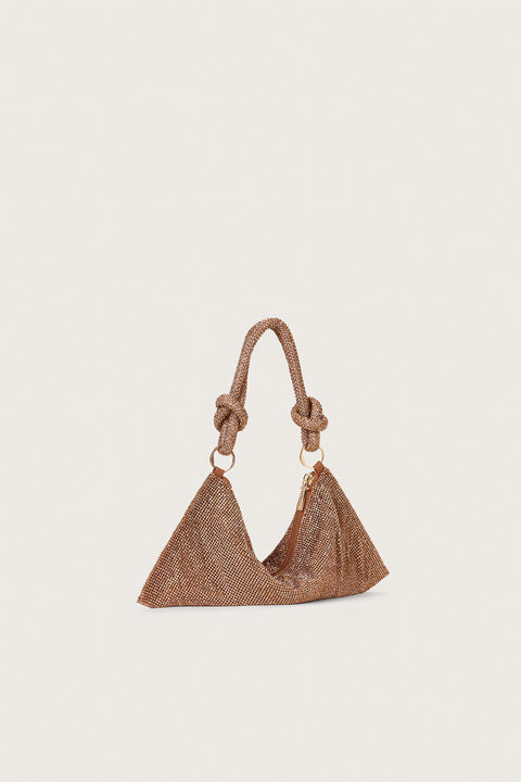 Side profile of a dark champagne colored, rhinestone handbag that is slouchy in shape and features a knotted double strap, connected by two gold-toned rings. 