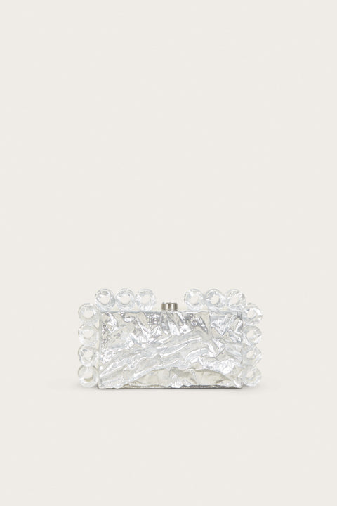 A rectangular acrylic clutch that features a silver foil design and matching open circles of silver-foiled acrylic lining the shape of the clutch.