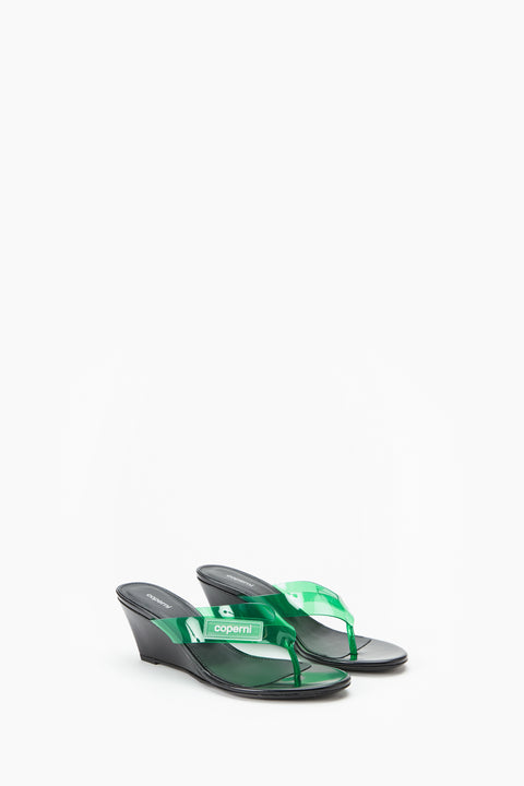Black wedge sandal with green strap on a white background from a side view.