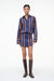 Woman wearing a blue and orange striped long sleeve mini dress with brown boots. 