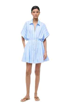 Woman wearing a light blue striped dress on a white background