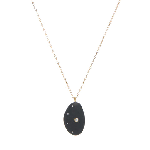 A cresent-shaped black stone, embellished with a round diamond and accented by a curve of smaller diamonds, further enhancing the crescent shape of the stone, all suspended on a yellow gold paperclip chain. 